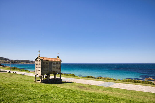 Photo of a horreo iin a park in front of the coast (Porto do Son, Galicia)