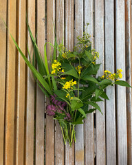 Bouquet of wild flowers in flat lay style on wooden background
