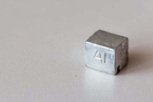 Aluminium cube with element name Al on it on cream background