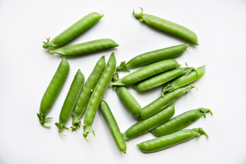 Pods of fresh green peas on a white background.