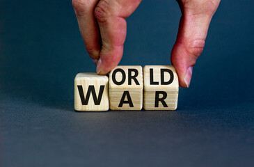World war symbol. Concept words World war on wooden cubes. Businessman hand. Beautiful grey table grey background. Business and World war concept. Copy space.