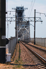 Electrified railway tracks and a bridge across the river.Transportation of goods over long...