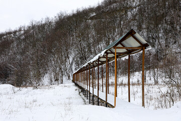 Wooden bridge to the hill in the forest in winter
