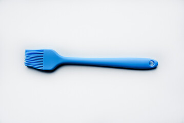 Blue plastic brush for smearing sunflower oil on a frying pan. A device for smearing oil.