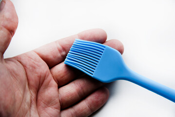 Blue plastic brush for smearing sunflower oil on a frying pan. A device for smearing oil.
