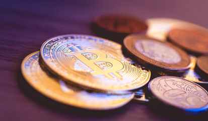 Bitcoin - Brasil. Moedas douradas de bitcoins com moedas brasileiras sobre uma superfície de madeira.  Conceitos de Criptomoedas, finanças e riscos.