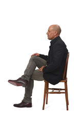 side view of a full portrait of a man sitting on chair with cross-legged on white background