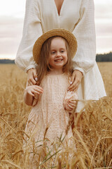 Mom and daughter in a wheat field