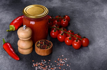 Spicy sweet tomato sauce with garlic, pepper and herbs in a glass jars