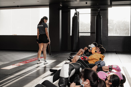 female trainer exercising kids in gym