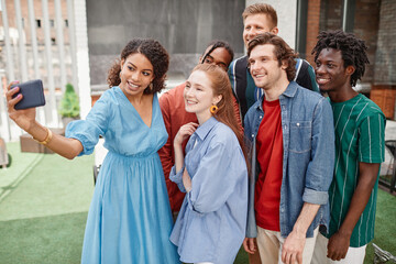 High angle portrait of diverse group of friends taking selfie at outdoor party
