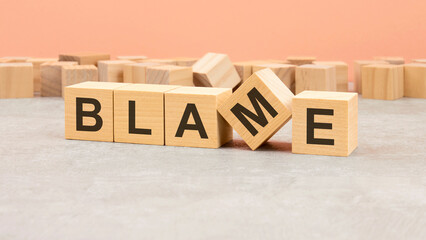word Blame made with wood blocks. text is written in black letters, light background
