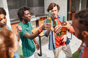 High angle view at diverse group of friends enjoying outdoor party and dancing with beer bottles