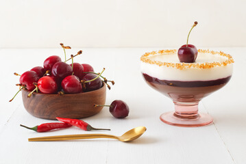 Dark and white chocolate mousse or panna cotta with chili cherry jelly in a glass with wooden bowl...