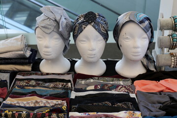 A mannequin stands on a showcase in a large store.