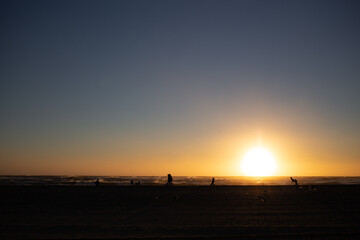 Fototapeta premium People at the beach during sunset