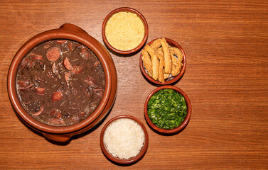 Delicious feijoada bowl with side dishes. Brazilian typical cuisine made with black beans and pork.