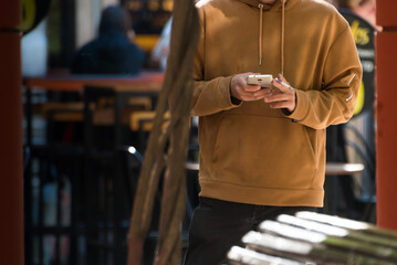 person standing on the sidewalk writing on a cell phone