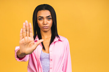 Close up portrait of serious young african american woman showing stop gesture with palm isolated...