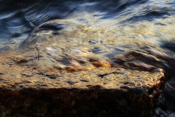 Small wave, stone and light reflection background - 520887086
