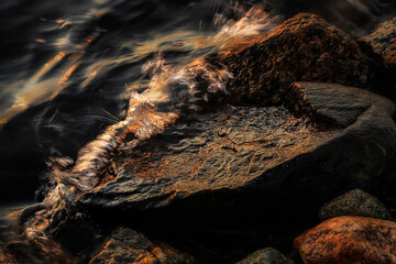 Small wave, stone and light reflection background - 520887087