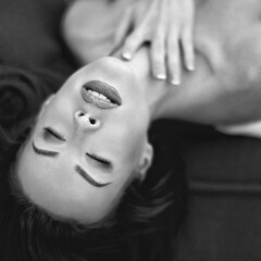 Passionate woman laying on sofa with closed eyes black and white