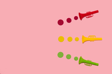 colorful trumpets play towards empty space on pink background, copy space, creative art music...