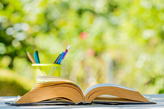outdoor open book with pen and natural background