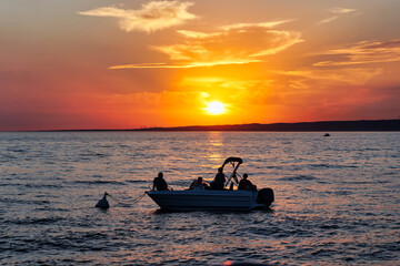 Small boat in front of the sunset. People enjoy the sunset on a boat. Boat at the ocean during...