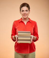 Obraz premium Student woman in red shirt holding books stack, isolated studio portrait.