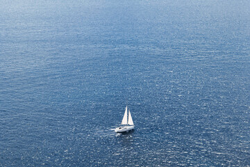 Arial photo of a sailboat cruising across the dark blue ocean. Yacht on the open sea. Yacht from...