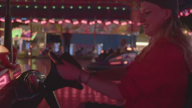 4k SlowMo - Young couple at the village fair, crashing cars. Boy flirting with her, they have a good time

