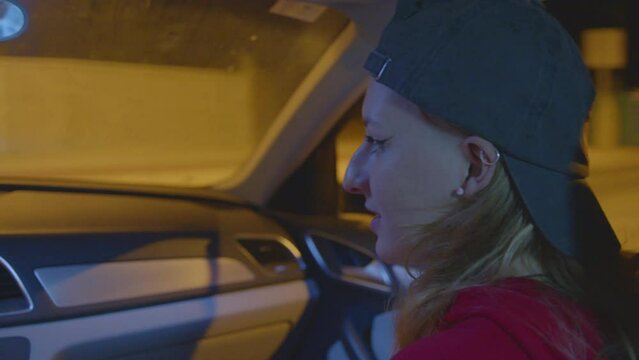 4k SlowMo - Girl hitchhiking on the road at night -boy picks her up, inside the car they listen to music, laugh, sing