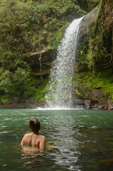Fototapeta na wymiar Young woman swimming at Garapia Cascade in Maquine, Rio Grande do Sul, Brazil