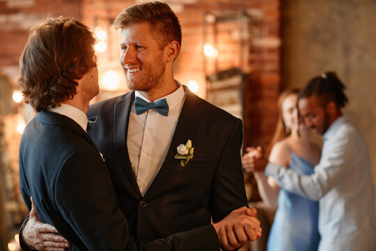 Portrait of happy gay couple dancing together during wedding ceremony, copy space