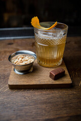 Alcoholic cocktail with peanuts and candy on a wooden table