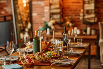 Warm toned background image of wooden dinner table set with dishes for cozy cabin party