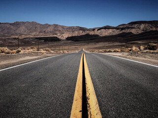 Asphalt road in the mountains. Death Valley. Driving Down Desert road in California.