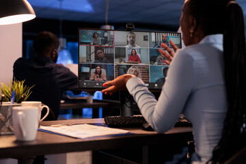 Project manager talking to business team on remote videocall, chatting on online teleconference call with colleagues. Using computer and webcam to attend videoconference telework meeting.
