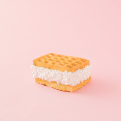An aesthetic arrangement made of waffles and white pearl filling on a pink background. Minimal dessert concept. Still life food inspiration.