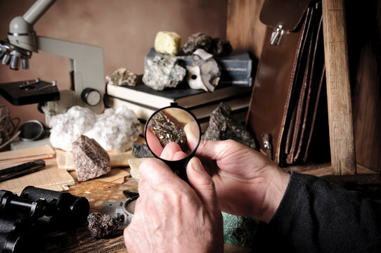 Geologist examining a mineral sample under a magnifying glass