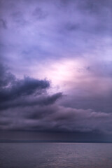 Fototapeta na wymiar Moody and dark purple clouds over the ocean