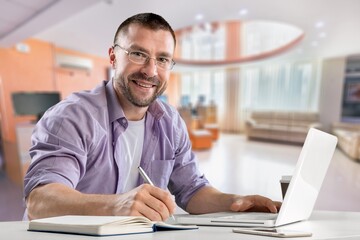 Satisfied man looking at computer screen, reading good news in email, chatting in social network with friends, freelancer blogger working on online project