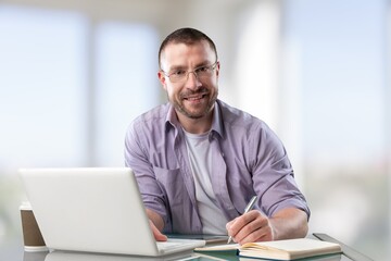 Satisfied man looking at computer screen, reading good news in email, chatting in social network with friends, freelancer blogger working on online project