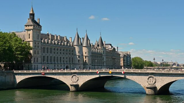 Nice footage of the Conciergerie Castle and Bridge of Change (Pont au Change) over the Seine. Passing of pedestrians and cars on the bridge, beautiful summer day.