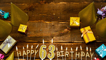 golden letters of the candle with the number happy birthday, the background of the gift boxes with...