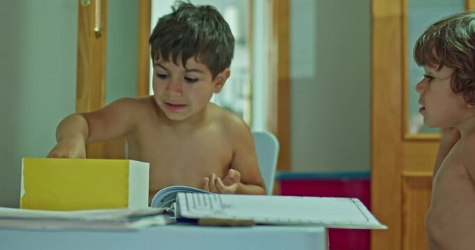 two kids doing homework back to class shirtless because of the heat.
