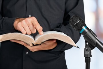Pastor with a Bible in hand during a sermon. The preacher delivers a speech