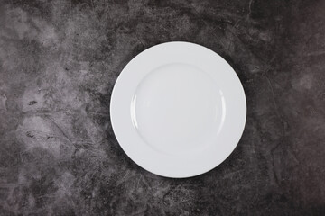 White dinner plate on a grey and white marble surface