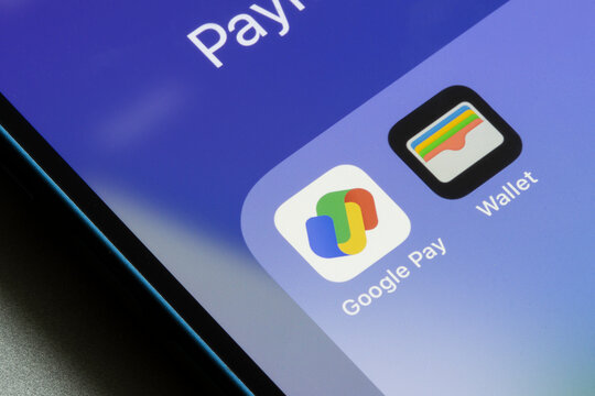 Portland, OR, USA - Aug 1, 2022: Google Pay and Apple Wallet app icons are seen on an iPhone. Digital wallet platform competitors concept.